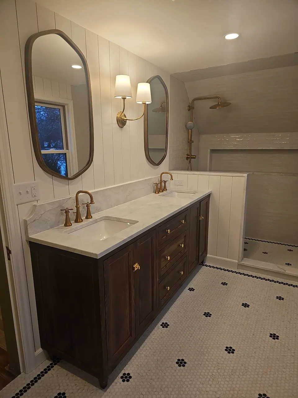 Bathroom with dark vanity and arched mirror
