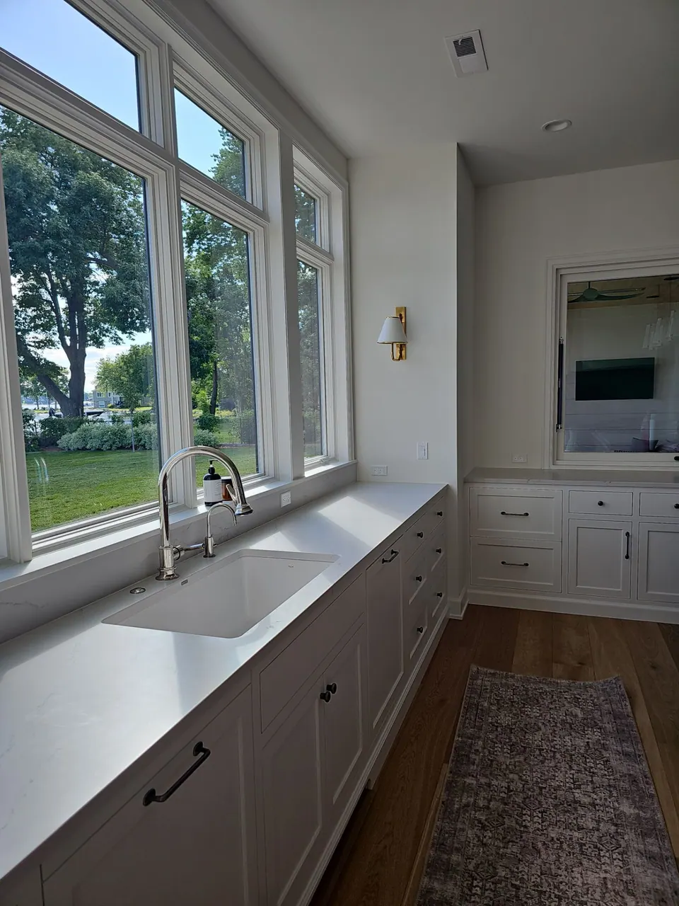 White kitchen cabinets around a sink window