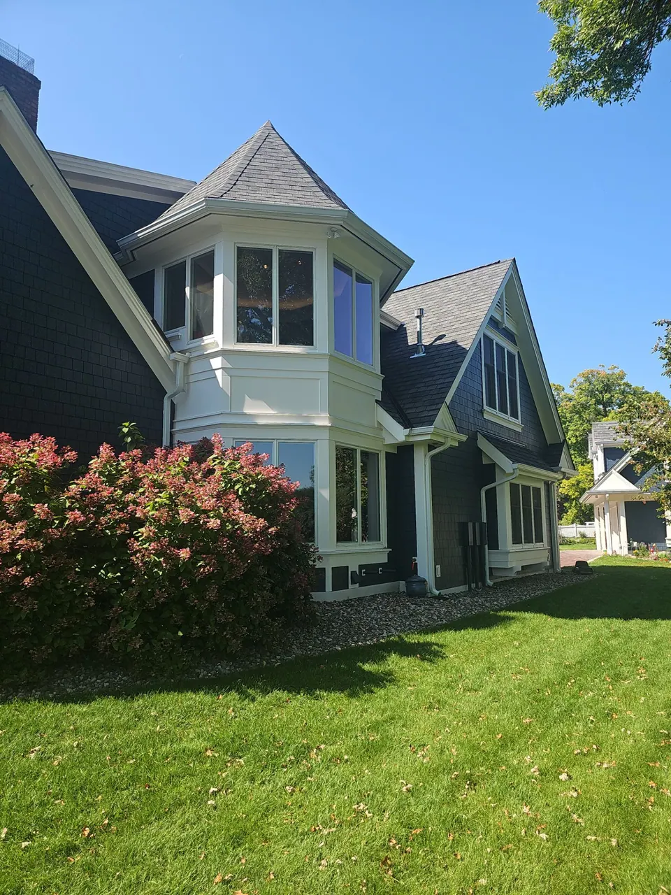 Navy shake-sided home with a turret bay and white trim