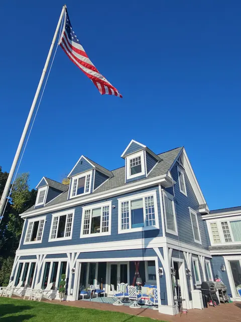 Two-story house with lap siding painted navy blue and crisp white trim around the windows and corners.