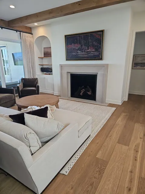 Living room with freshly painted white walls and a fireplace surround, trim and ceiling finished in matching white.